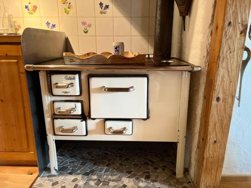 an old stove with four drawers in a kitchen at Siebenschläferhütte in Buchenberg