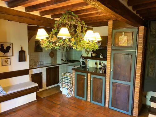 a large kitchen with a table and a chandelier at Villa Rosa di Chianti in Radda in Chianti