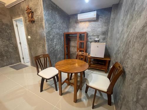 a dining room with a wooden table and chairs at MONDEE House @The Airport in Thalang
