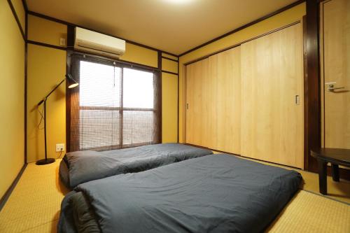 Postel nebo postele na pokoji v ubytování Guest House 伏見稲荷