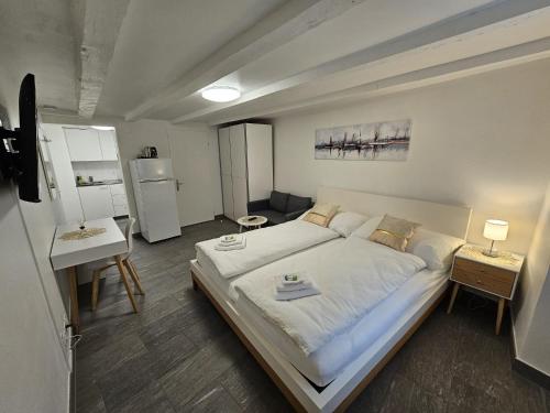 a bedroom with a large bed and a kitchen at Hotel Surselva in Chur