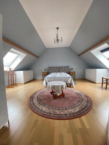 Camera mansardata con letto e tappeto. di La Maison d'Aimé - Spacieuse et grand jardin a Banville