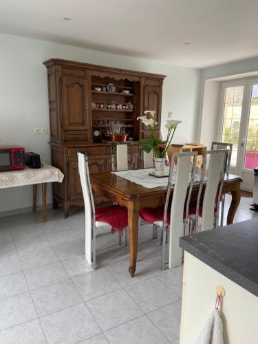 une salle à manger avec une table et des chaises en bois dans l'établissement La Maison d'Aimé - Spacieuse et grand jardin, à Banville