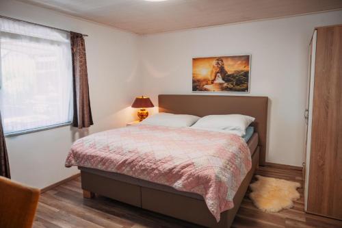 a bedroom with a bed and a window at Bungalow Donaublick mit Pool und Garten in Sankt Nikola an der Donau