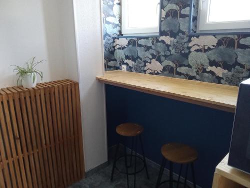 un bar avec deux tabourets à côté d'un radiateur dans l'établissement La villa DEF'S, à Huppy