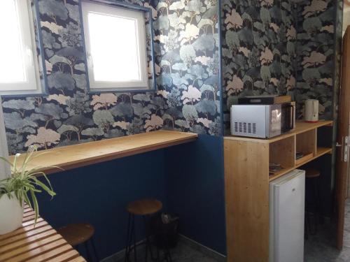 Cette chambre est dotée d'un mur bleu avec du papier peint floral. dans l'établissement La villa DEF'S, à Huppy