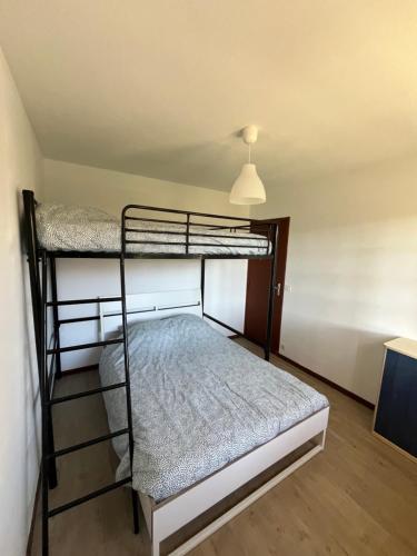 une chambre avec deux lits superposés dans une pièce dans l'établissement Maison grand terrain 200m Plage, à Capbreton