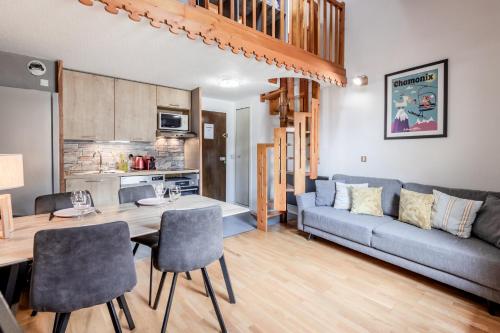 un salon avec un canapé, une table et des chaises dans l'établissement Triplex - Hypercentre - Balcon avec vue montagnes, à Chamonix-Mont-Blanc