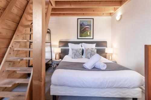 une chambre avec un grand lit et un escalier dans l'établissement Triplex - Hypercentre - Balcon avec vue montagnes, à Chamonix-Mont-Blanc