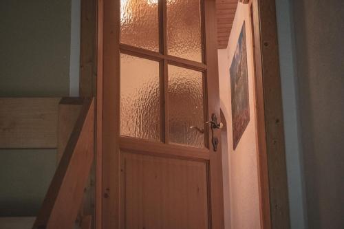 a wooden door with glass panels in a room at Haus Bergwind in Sankt Leonhard im Pitztal