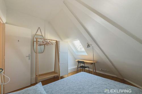 - une chambre mansardée avec un lit et un bureau dans l'établissement Flexliving - room - Bausset, à Paris