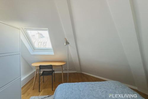Cette petite chambre comprend une table et un lit. dans l'établissement Flexliving - room - Bausset, à Paris