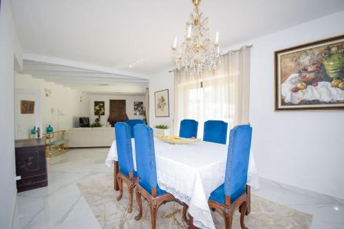 a dining room with a table and blue chairs at White Star Estoril in Estoril