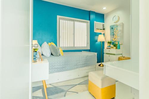 a blue bedroom with a bed and a window at Cozy Modern 2BR Loft, Monterrazas, Cebu City in Baksan