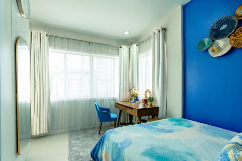 a blue bedroom with a desk and a blue wall at Cozy Modern 2BR Loft, Monterrazas, Cebu City in Baksan