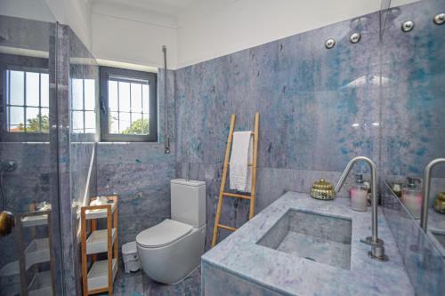 a bathroom with a tub and a toilet and a sink at White Star Estoril in Estoril