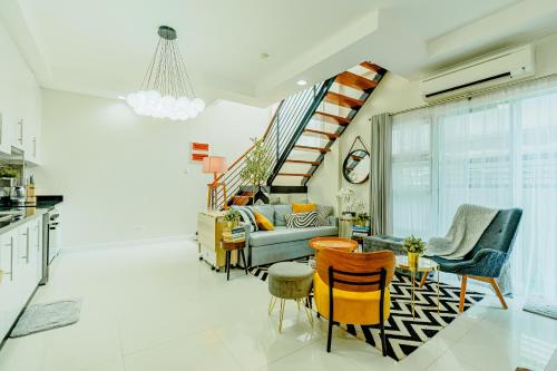 a living room with a couch and a table and chairs at Cozy Modern 2BR Loft, Monterrazas, Cebu City in Baksan
