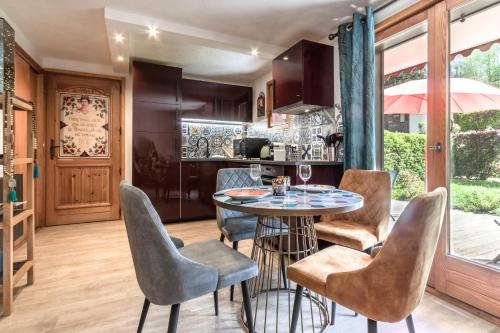 une cuisine avec une table et des chaises dans une cuisine dans l'établissement Les jardins de Taconnaz - Les Houches, aux Houches