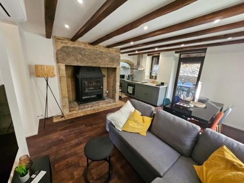 a living room with a couch and a fireplace at Charmante Maisonette du Lot rénovée avec balnéo in Latouille-Lentillac