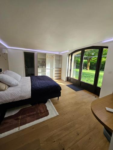 une chambre avec un lit et une grande fenêtre dans l'établissement Charmante Maisonette du Lot rénovée avec balnéo, à Latouille-Lentillac