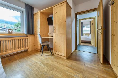 a room with a chair and a desk and a window at Platzhirsch Rooms - B&B - SELF CHECK-IN in Piesendorf