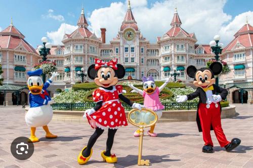 a group of mickey mouse costumes in front of the disney palace at Bienvenue chez nous in Noisy-le-Grand