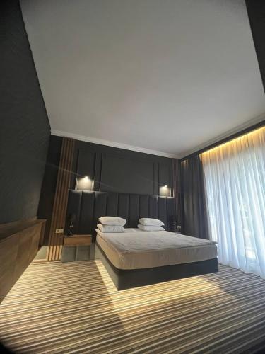 a bedroom with a large bed and a window at Sapar Standart Hotel LUXE Люкс из двух комнат in Shymkent