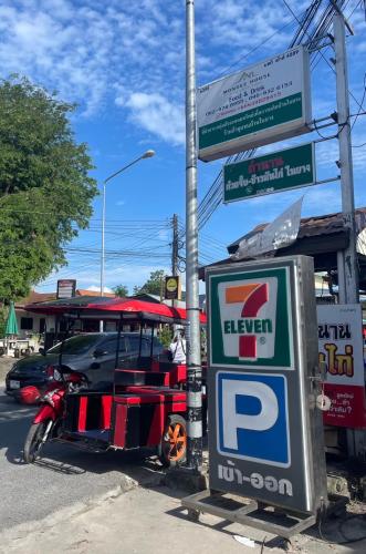 a gas station with a motorcycle parked next to a sign at MONDEE House @The Airport in Thalang