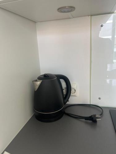 a black coffee pot sitting on a kitchen counter at Møblert ferieleilighet i det fineste stedet i byen in Kristiansand