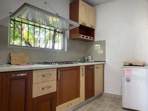 a kitchen with wooden cabinets and a sink and a window at Noemi House in Krujë