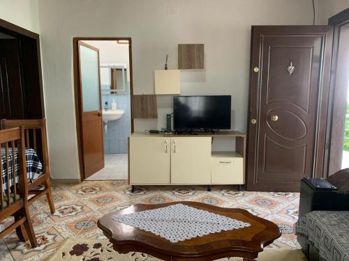 a living room with a tv and a door at Noemi House in Krujë