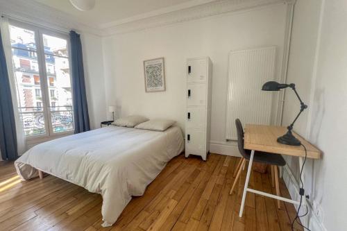 une chambre avec un lit, un bureau et une lampe dans l'établissement Flexliving - Bedroom - Paris 18, à Paris