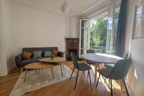 un salon avec un canapé, une table et des chaises dans l'établissement Flexliving - Bedroom - Paris 18, à Paris