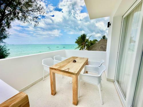 a table and chairs on a balcony with a view of the ocean at OceanView Penthouse Mirage ZanzibarHouses in Kiwengwa