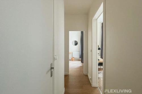 un couloir avec une porte menant à une chambre dans l'établissement Flexliving - Room - Mesnil, à Paris
