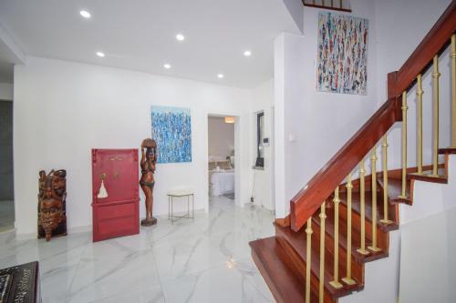 a living room with a staircase and paintings on the wall at White Star Estoril in Estoril