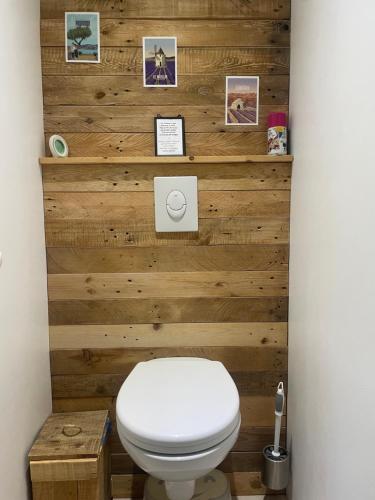 bagno con parete in legno e servizi igienici. di Maison d'hôtes les Jardinettes en Luberon a Villelaure