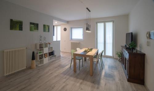 a living room with a table and chairs and a television at Casa Vacanze SweetLand Chiavenna in Chiavenna