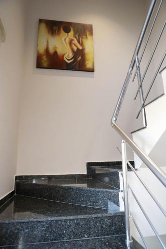 a painting hanging on a wall next to some stairs at Hotel ANTONIA in Tirana