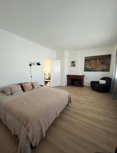 une chambre blanche avec un lit et un bureau dans l'établissement Casa Edgar, à Perpignan