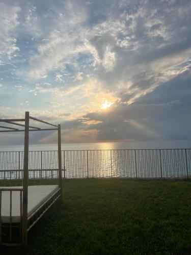 a view of the ocean with a bed and a fence at Cozy Flat At Bamboo Beach Tsikhisdziri in Tsikhisdziri