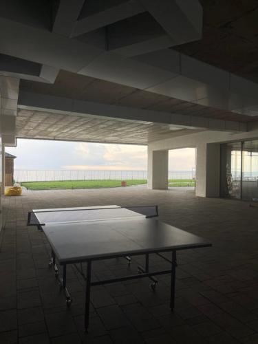 a ping pong table sitting inside of a building at Cozy Flat At Bamboo Beach Tsikhisdziri in Tsikhisdziri