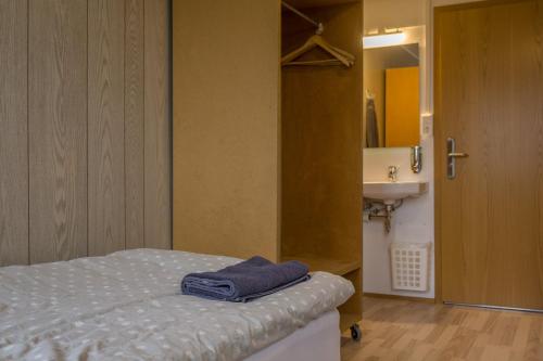 a room with a bed and a bathroom with a sink at Vogar Travel Service in Myvatn