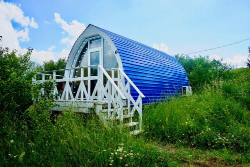 a blue barn sitting in a field of grass at Glamping Eco Valley in Shahumyan