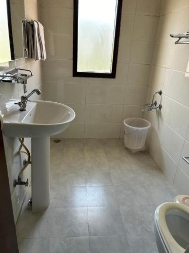 a bathroom with a sink and a toilet at Couple friendly Deluxe Rooms Kasauli Hills Kumarhatti in Dagshai