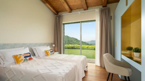 Un dormitorio con una cama y una ventana grande. en VILLA KRISZTINA 10, Emma Villas, en Bagnone