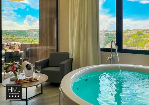 a room with a bath tub in a hotel room at Hotel Spa Mirador in Jorquera