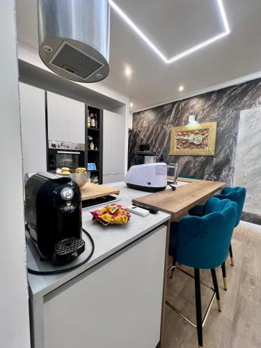 a kitchen with a counter with a toaster and blue chairs at Zoelia Casilina House in Rome