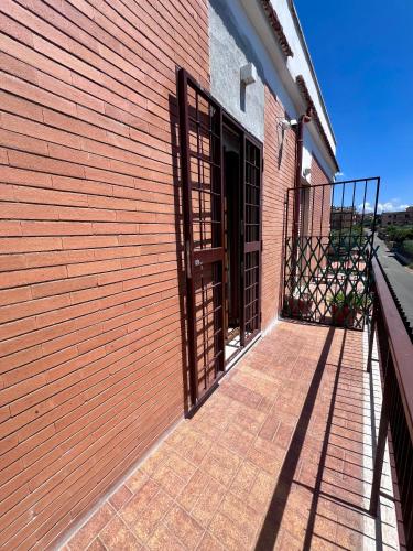 an open door on a brick building with a fence at Zoelia Casilina House in Rome