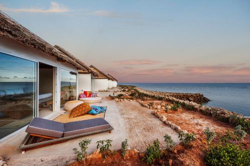 a house with a balcony with a view of the ocean at La Crique Nature & Spa in Dakhla